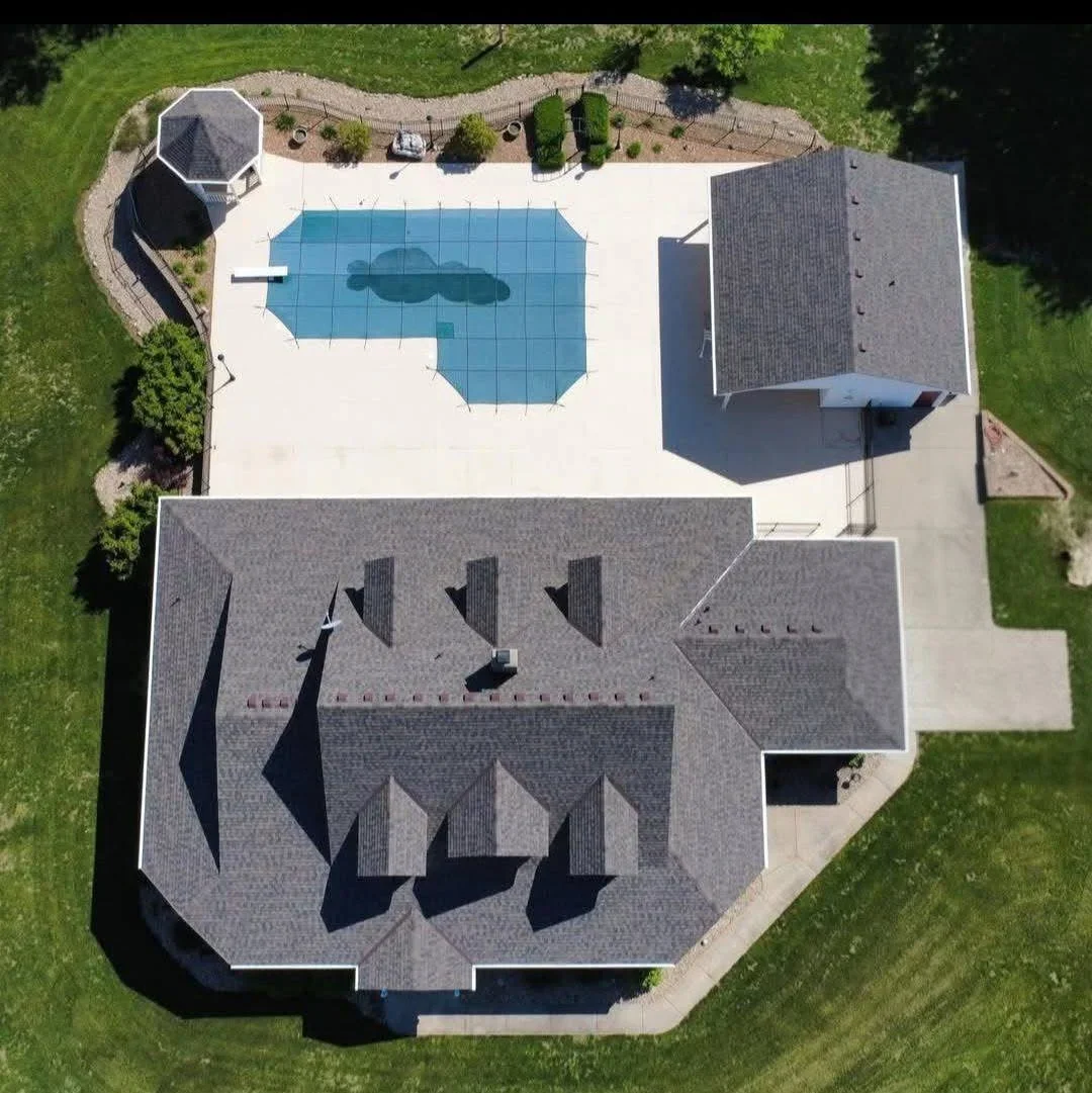 Aerial view of residential roof with gray dimensional asphalt shingles and multiple roof planes