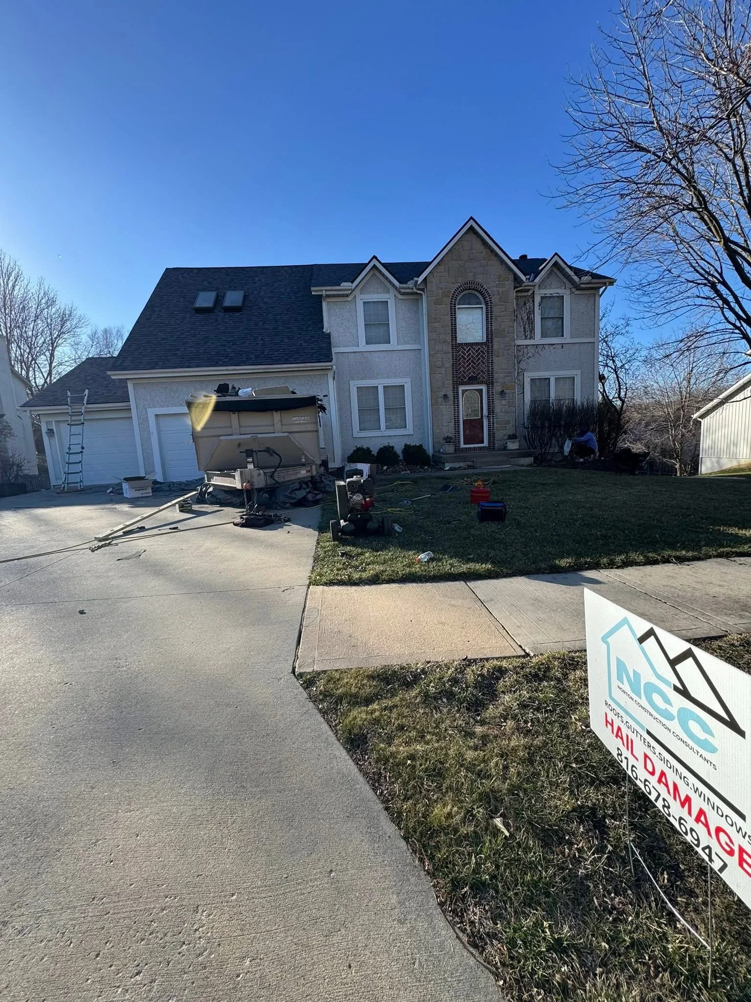 Two-story home with newly installed dark gray asphalt shingle roof and multiple gables